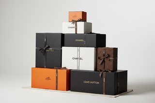 stack of boxes with dior chanel hermes fendi logos